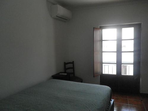 タヴィラにあるCasa Barrela IIのベッドルーム(ベッド1台、窓付)
