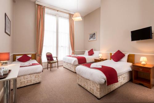um quarto de hotel com duas camas e uma televisão em Abbott Lodge em Dublin