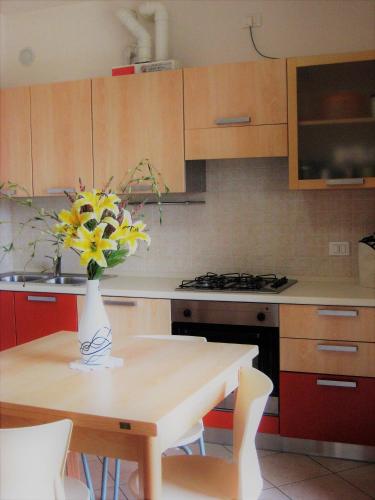 a kitchen with a table with a vase of flowers on it at RESORT VILLAGE AQUA MARINA FAMILY - Daily Rooms Tidying - CocktailsBar- Pet Friendly - with Hypermarket - Delivery Restaurant-Pizzeria - Room Breakfast with supplement - Ultra Fast Wi-Fi - Play Area for children - Olympic Swimming Pool - Parking in Caorle