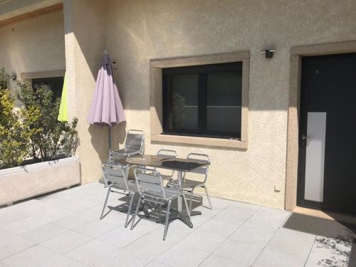 a table and chairs and an umbrella on a patio at Gites Des Sablons in Châtillon-sur-Marne