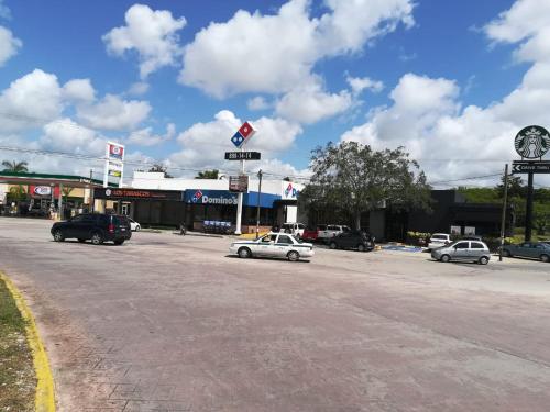 a street with cars parked in front of a gas station at Departamento en Dream Lagoons Cancun in Cancún