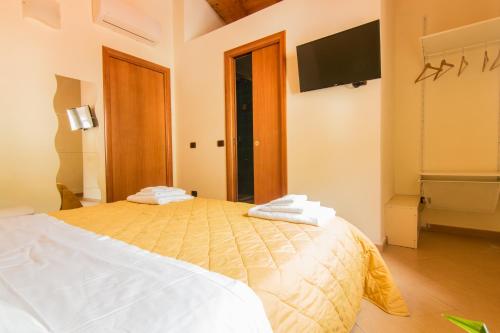 a bedroom with a bed and a flat screen tv at B&B Sotto un Tetto in Cetara
