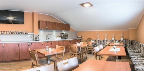 a restaurant with wooden tables and a bar at Penzion Hluk in Hluk