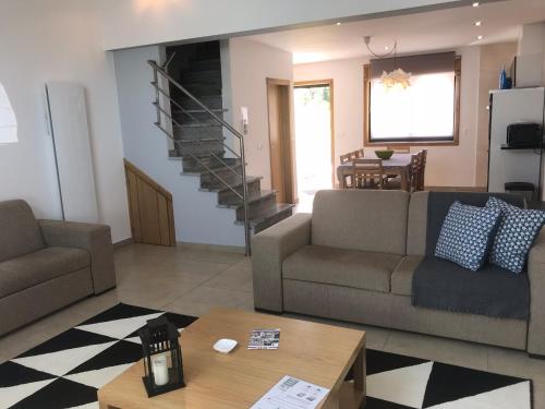 a living room with two couches and a staircase at Gites Des Sablons in Châtillon-sur-Marne