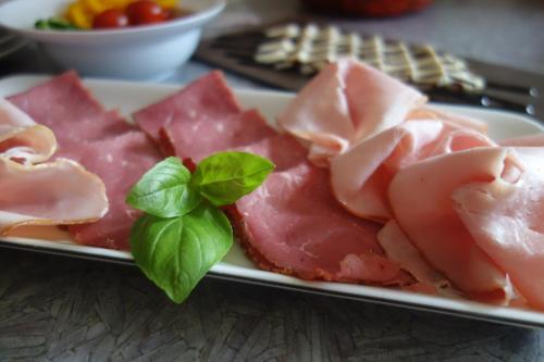 a plate of cured meats with a basil leaf on it at Gästehaus Daurer in Reinsberg