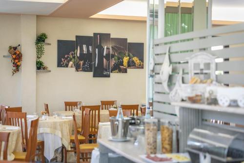 a dining room with tables and chairs in a restaurant at Hotel del Falco in Cervia