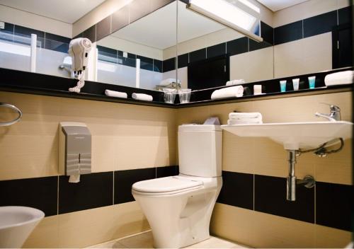 a bathroom with a white toilet and a sink at Noiva do Mar in Lourinhã