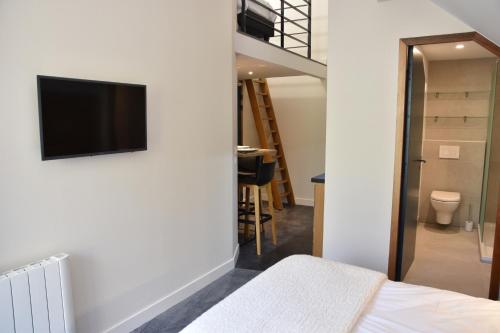 a bedroom with a bed and a tv on a wall at Appart'Hotel Aiguille Verte & Spa in Chamonix-Mont-Blanc