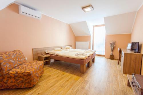 a bedroom with a bed and a chair at Penzion Hluk in Hluk