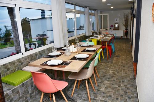 a restaurant with wooden tables and colorful chairs at La Casa de la Abuela in Ponta do Sol