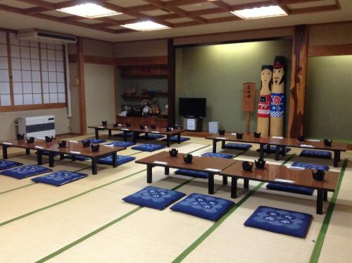 a classroom with tables and a wall with a picture of two dolls at Kadowakikan in Nozawa Onsen