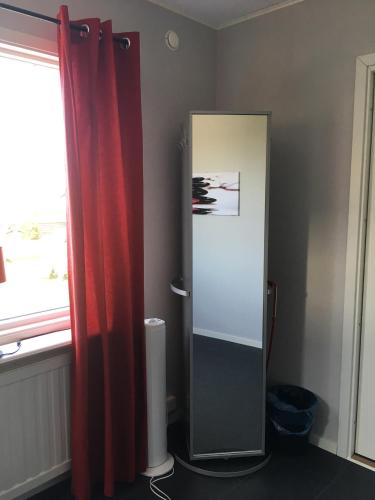 a bathroom with a mirror and a red curtain at Gamla Bryggeriet Bed & Breakfast in Köpingsvik