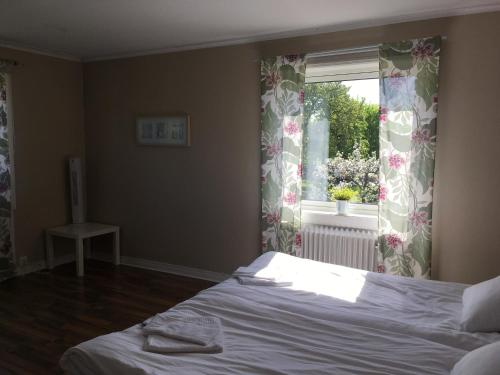 a bedroom with a bed and a window at Gamla Bryggeriet Bed & Breakfast in Köpingsvik