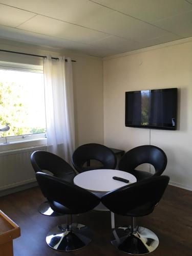 a room with a table and chairs and a tv at Gamla Bryggeriet Bed & Breakfast in Köpingsvik