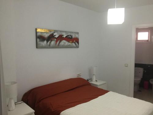 ロンダにあるM.L Los Vicentesのベッドルーム1室(ベッド1台付)が備わります。壁には絵画が飾られています。