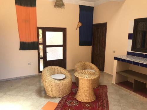 a living room with two chairs and a table at Kasbah Rayane Ait Ben Haddou in Aït Ben Haddou