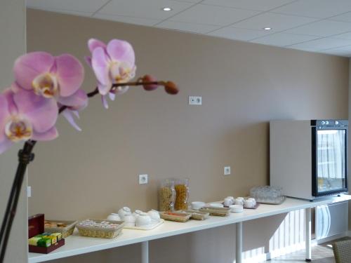 une étagère avec des orchidées violettes dessus dans l'établissement Hôtel Terminus, à Nantes