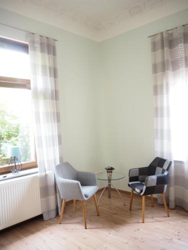 two chairs and a table in a room with a window at "Glücksmoment" in Bad Kreuznach