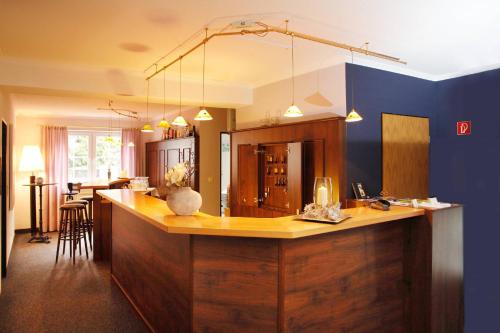 a kitchen with a counter and a blue wall at Hotelpension zum Gockl in Allershausen