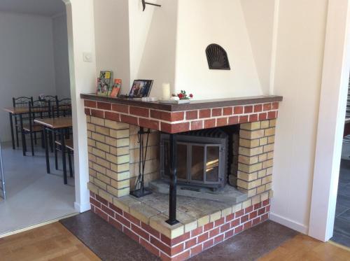 a brick fireplace in a room with a table at Gamla Bryggeriet Bed & Breakfast in Köpingsvik
