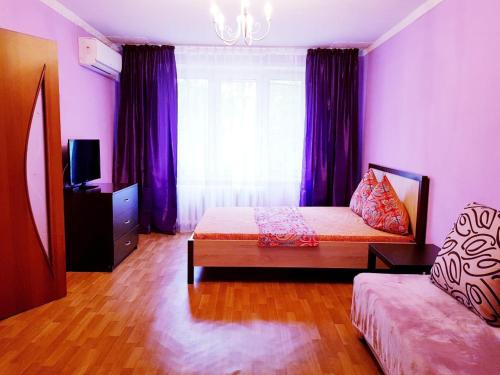 モスクワにあるКвартира посуточно метро Пролетарскаяの紫の壁のベッドルーム1室、ベッド1台、窓が備わります。