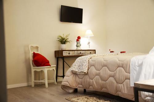 a bedroom with a bed and a desk with a red pillow at B&B Al borgo in Frascati