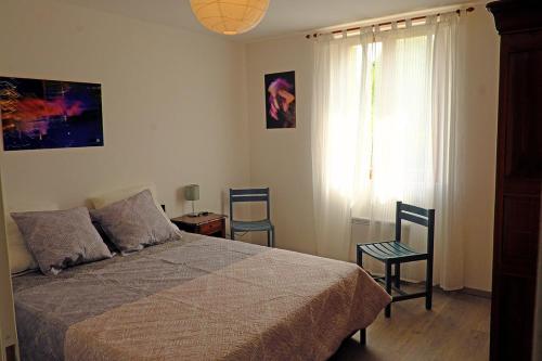 - une chambre avec un lit, deux chaises et une fenêtre dans l'établissement Envies en Lubéron, à Saignon
