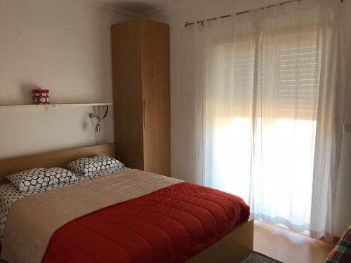 a bedroom with a bed and a large window at Apartamento Porto de Areia in Peniche