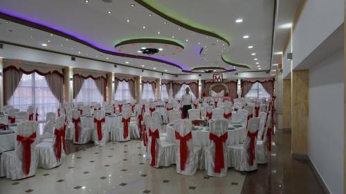 a room full of tables and chairs with a man standing in the middle at Meka Hotel in Dragash