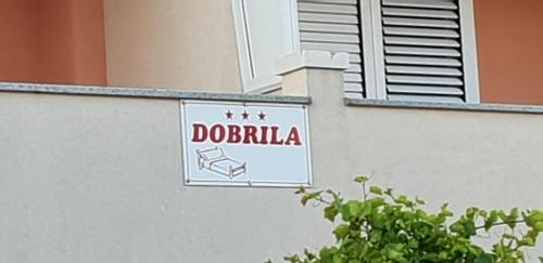 a sign on the side of a building at Apartments and Rooms Dobrila in Jelsa