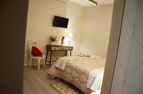 a bedroom with a bed and a desk with a television at B&B Al borgo in Frascati