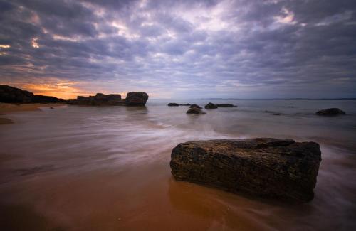 a large rock in the water on a beach at Foxy's Den Dornoch in Dornoch