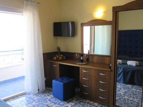a bedroom with a desk and a mirror at Hotel Panoramic in Giardini Naxos