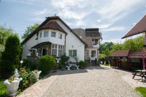 a white house with a tiled roof at Vila Daiana- Acceptam vouchere vacanta in Moieciu de Jos