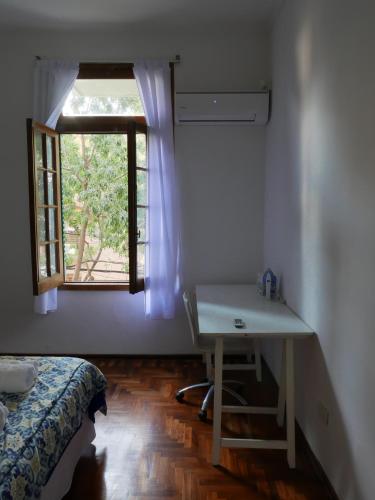 a bedroom with a bed and a desk and a window at Roosevelt in Buenos Aires