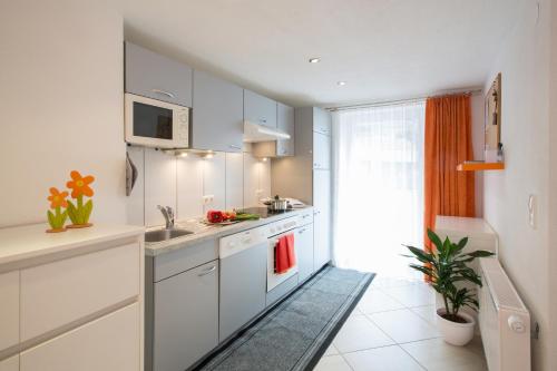 a kitchen with white cabinets and a sink at Apart Hofer in Nauders