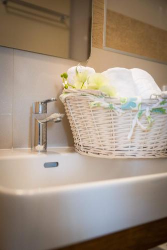 a bathroom sink with a basket of towels and a mirror at Apartment Navis in Dubrovnik