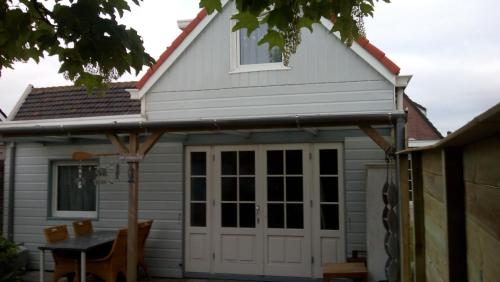 a house with a white garage door and a table at Close to the beach in Wijk aan Zee