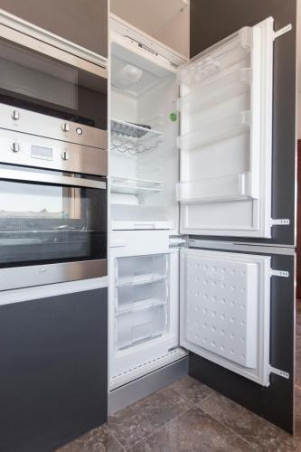 an empty refrigerator with its door open in a kitchen at Premium apart - Praia do Furadouro in Ovar