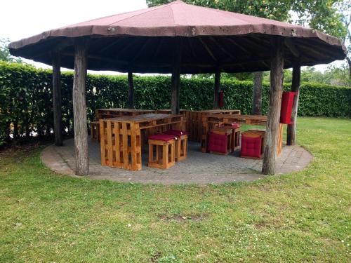 a gazebo with benches and tables in the grass at Agriturismo Podernuovo in Acquapendente