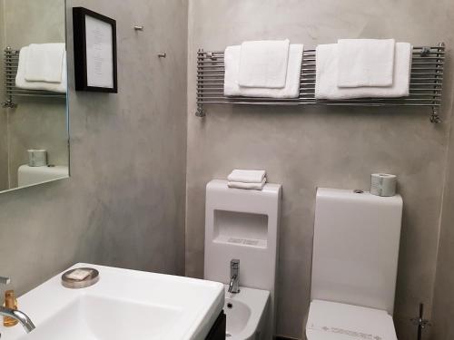 a bathroom with a sink and a toilet and towels at MA Hotel in Santa Margherita Ligure