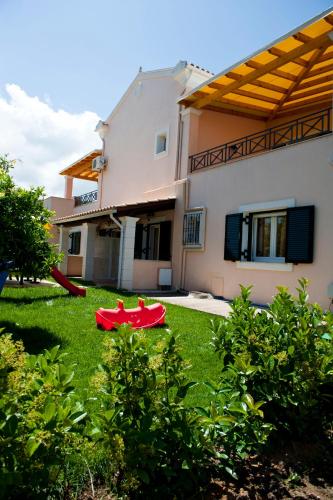 a house with a red table in the yard at Anna Apartments in Acharavi