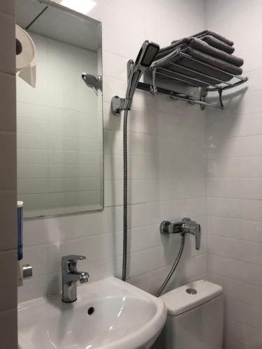 a bathroom with a sink and a mirror and a toilet at Hang Fung Hostel in Hong Kong