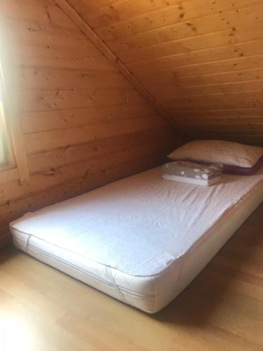 a bed in a cabin with a wooden ceiling at Domki Międzyzdroje in Międzyzdroje