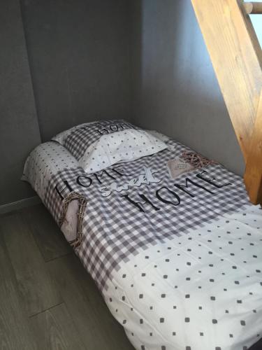 - un lit avec une couverture en damier dans l'établissement Appartement cosy et agreable, à Cagnes-sur-Mer
