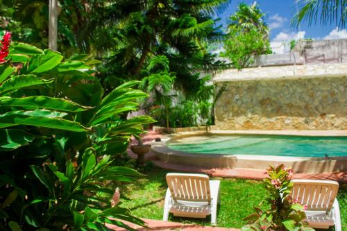 two chairs and a swimming pool in a yard at Casa De Los Pájaros - B&B in Valladolid