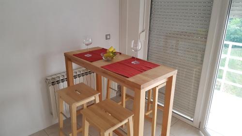 a small wooden table with two glasses of wine at Studio Concept Apartment in Zagreb