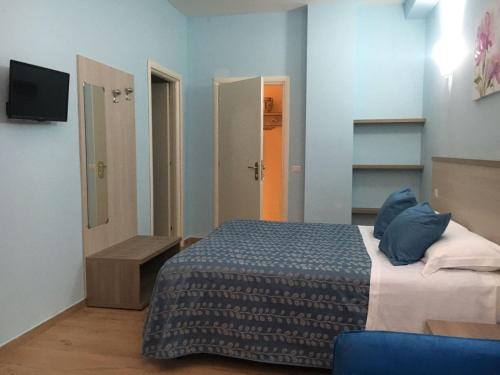 1 dormitorio con 1 cama y TV. en La Conchiglia en Sperlonga
