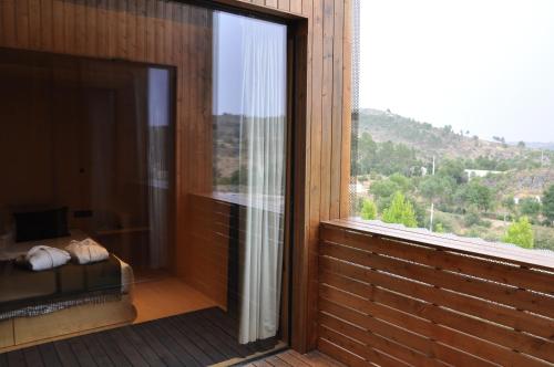 a room with a large window with a view of a mountain at Cró Hotel Rural in Rapoula do Côa