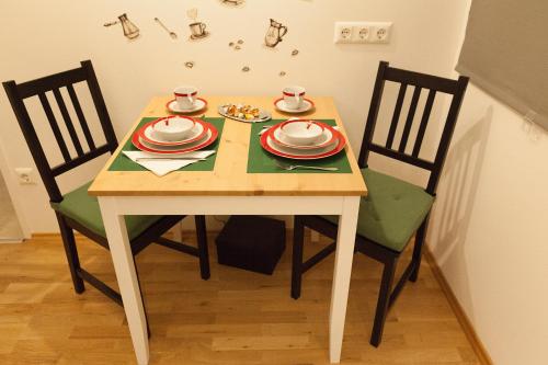 een tafel met twee stoelen en borden en bekers erop bij Karmeliter Home in Wenen
